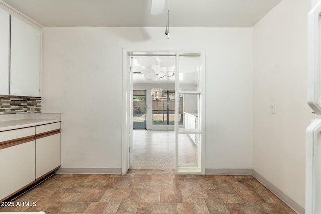 2002 W Whitton Ave, Phoenix, AZ 85015 - unfurnished dining area with stone finish floors, a chandelier, and ceiling fan