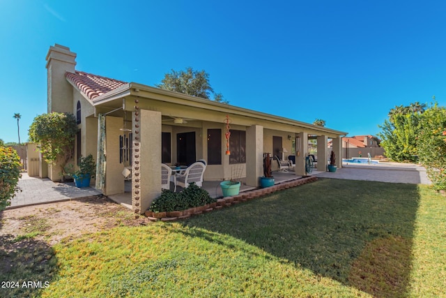 back of property featuring a lawn and a patio area