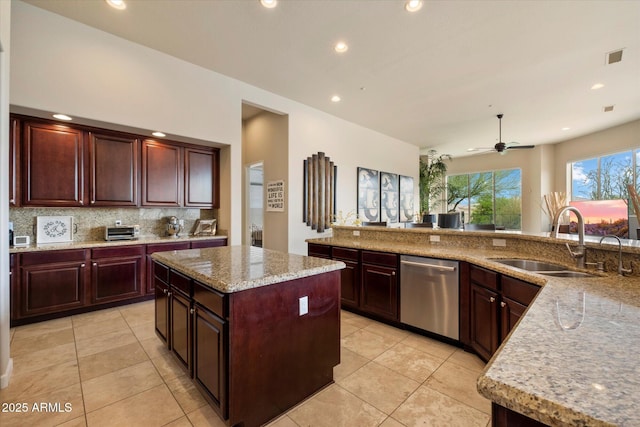 kitchen featuring stainless steel dishwasher, a sink, decorative backsplash, a kitchen island, and light tile patterned floors