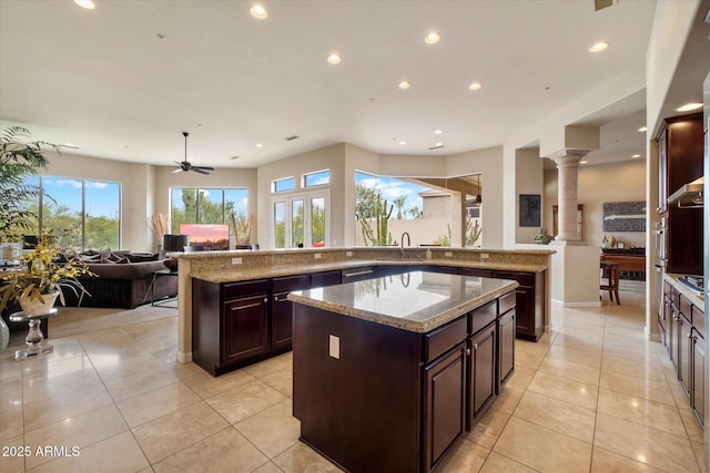 kitchen with recessed lighting, a kitchen island, open floor plan, and light tile patterned floors