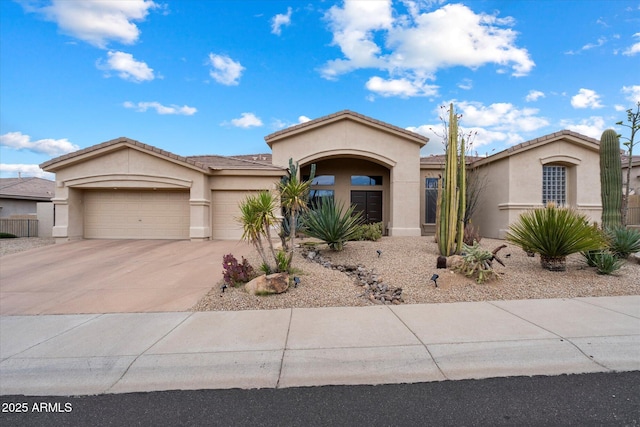 view of front of house featuring stucco siding, an attached garage, driveway, and a tile roof
