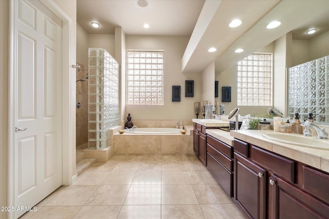 full bath with tile patterned floors, a bath, tiled shower, vanity, and recessed lighting