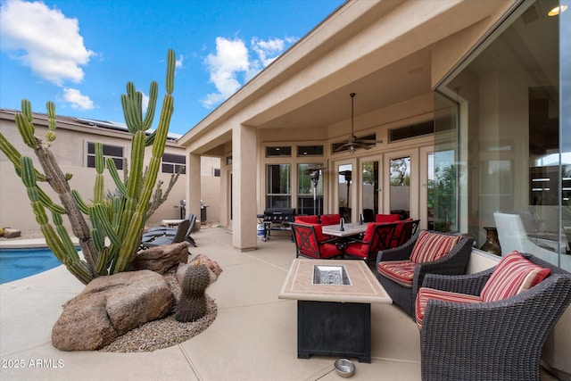 view of patio with an outdoor pool, a ceiling fan, and an outdoor fire pit