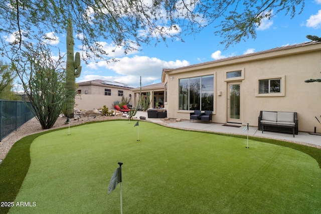 rear view of house featuring fence, an outdoor hangout area, stucco siding, and a patio