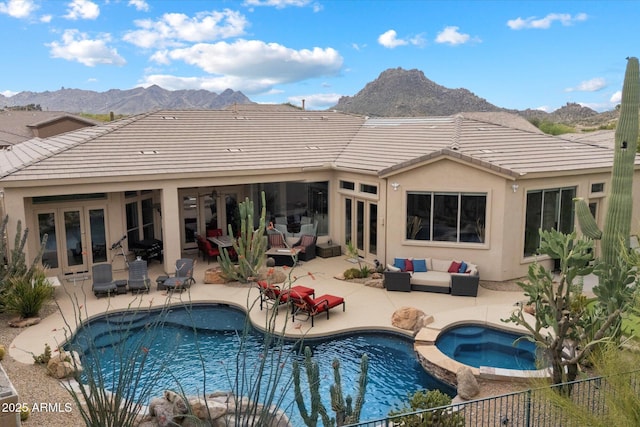back of property with an outdoor hangout area, french doors, a patio, and a mountain view