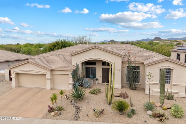 view of front facade featuring a tile roof, driveway, a mountain view, a garage, and stucco siding