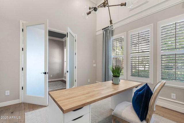 office area with baseboards, a wealth of natural light, and light wood-style flooring