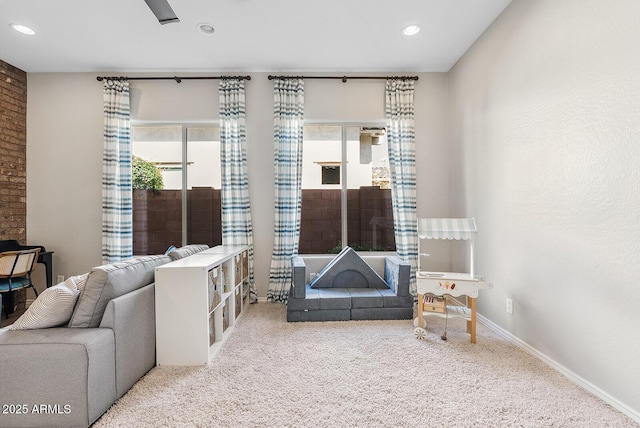sitting room featuring carpet flooring, recessed lighting, and baseboards