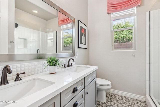bathroom featuring a sink, toilet, and a healthy amount of sunlight