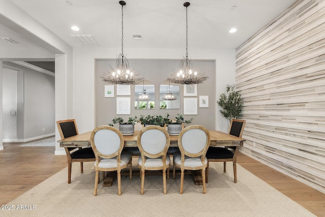 dining space with visible vents, wood finished floors, baseboards, an inviting chandelier, and recessed lighting