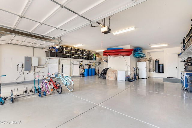 garage with freestanding refrigerator, a garage door opener, and water heater