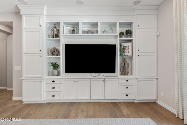 unfurnished living room featuring baseboards and light wood-type flooring