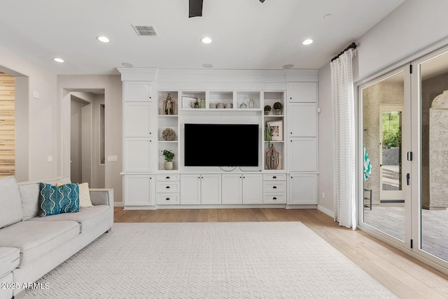 living room featuring light wood-style floors, recessed lighting, baseboards, and visible vents