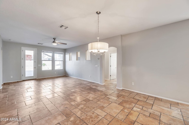 spare room featuring ceiling fan with notable chandelier