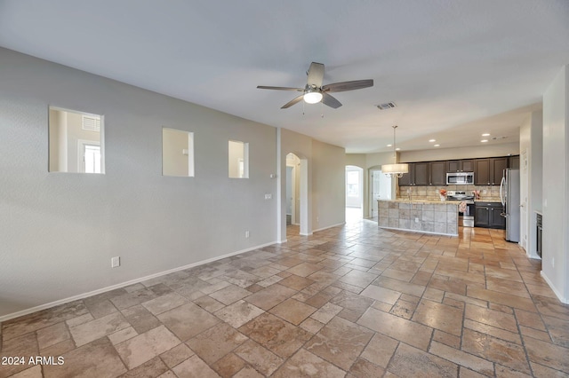 unfurnished living room with ceiling fan