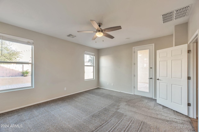 carpeted spare room featuring ceiling fan