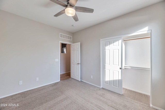 unfurnished bedroom with ceiling fan, light carpet, and a closet