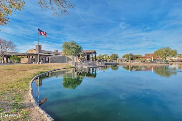 view of swimming pool with a water view and a lawn