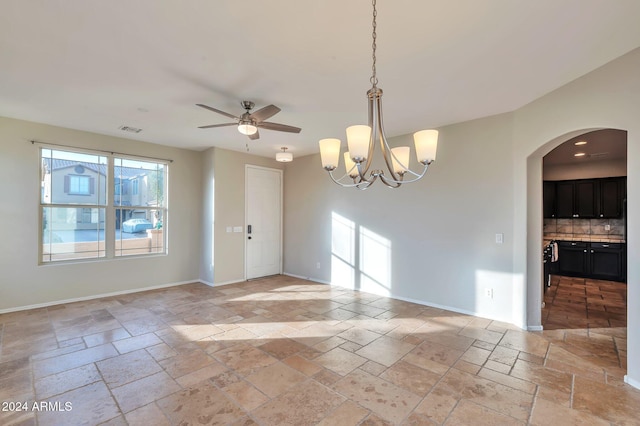 unfurnished room featuring ceiling fan with notable chandelier