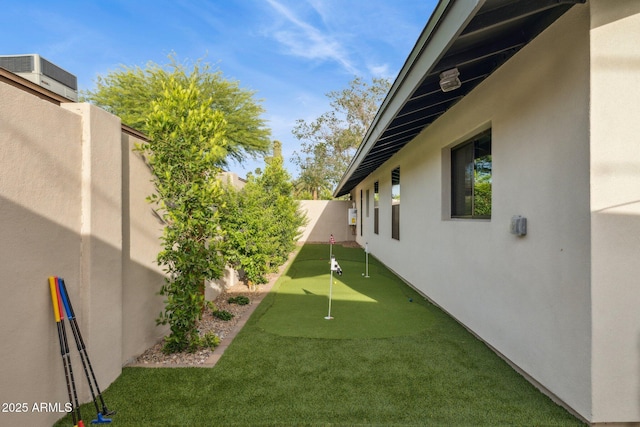 fenced backyard with an area to practice putting