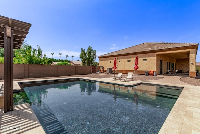 view of swimming pool with cooling unit and a patio area