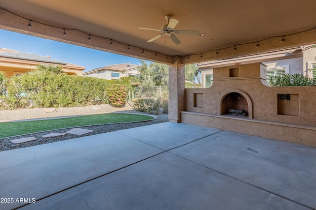 view of patio / terrace featuring ceiling fan and exterior fireplace