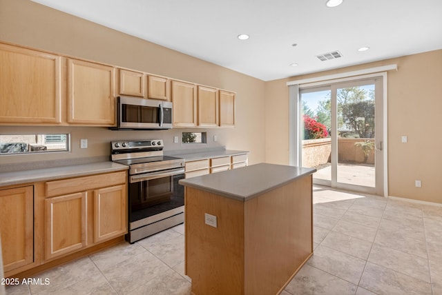 kitchen featuring stainless steel appliances, a center island, light tile patterned floors, and light brown cabinets