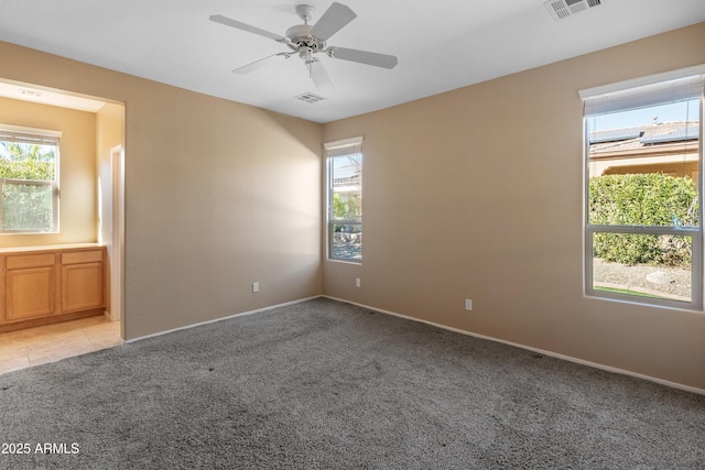 carpeted spare room featuring ceiling fan