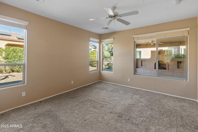 carpeted spare room featuring ceiling fan