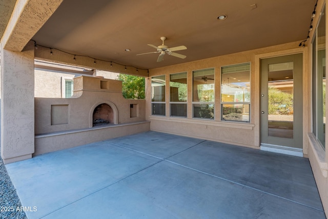 view of patio featuring ceiling fan and an outdoor fireplace