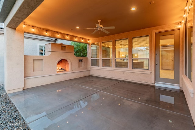 view of patio / terrace with ceiling fan and exterior fireplace