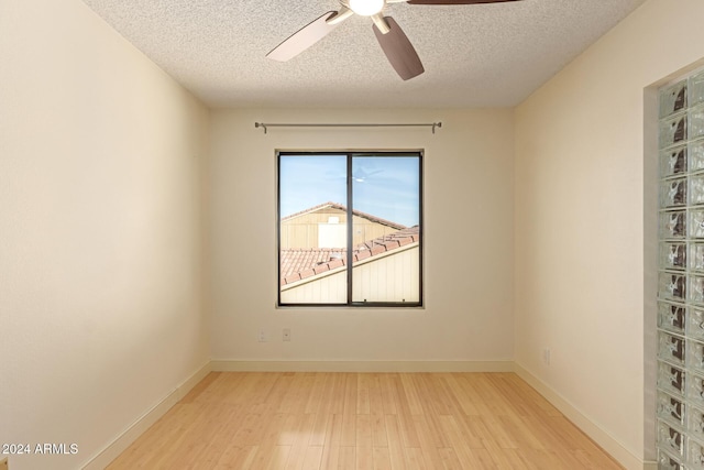 unfurnished room featuring ceiling fan, a textured ceiling, and light wood-type flooring