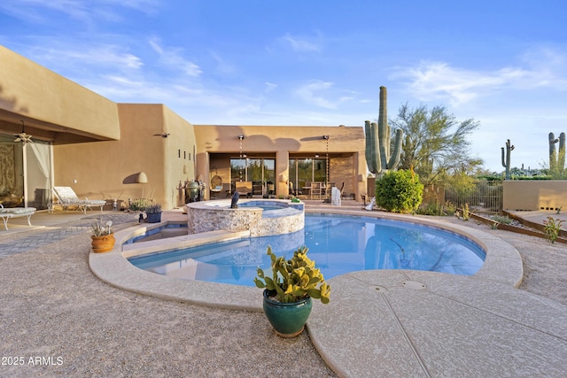 view of swimming pool with a ceiling fan, a patio area, fence, and a pool with connected hot tub