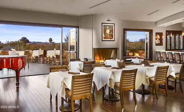 dining area with plenty of natural light, hardwood / wood-style flooring, and visible vents