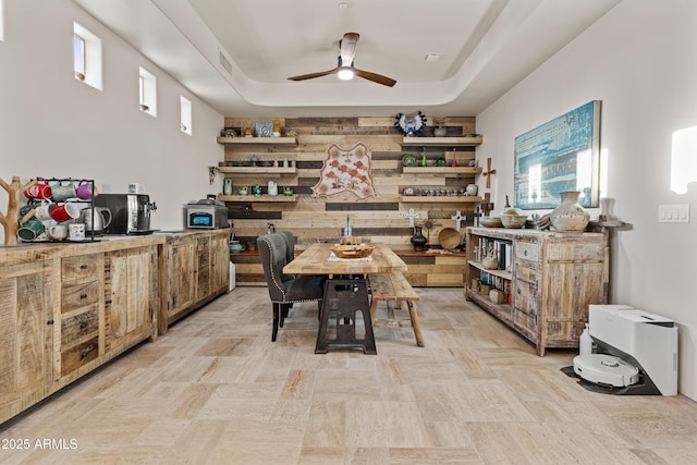 dining space with ceiling fan, visible vents, and a tray ceiling