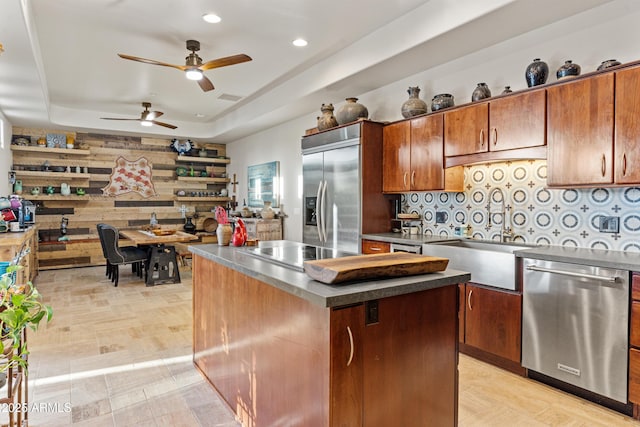 kitchen featuring ceiling fan, a sink, stainless steel appliances, recessed lighting, and a tray ceiling