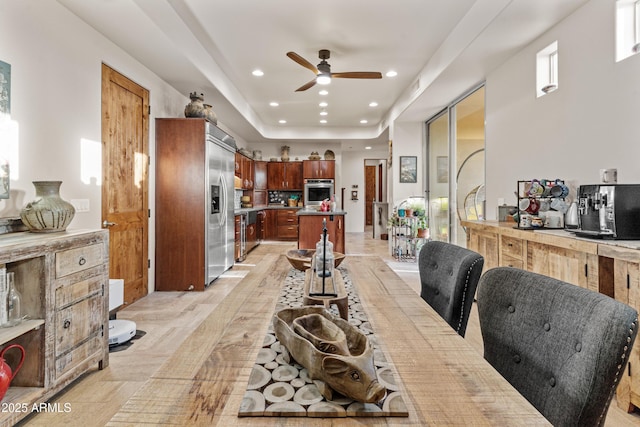 dining room with a ceiling fan, a tray ceiling, and recessed lighting
