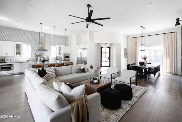 living room featuring dark hardwood / wood-style flooring and ceiling fan with notable chandelier