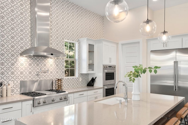 kitchen featuring white cabinetry, sink, wall chimney range hood, and stainless steel appliances