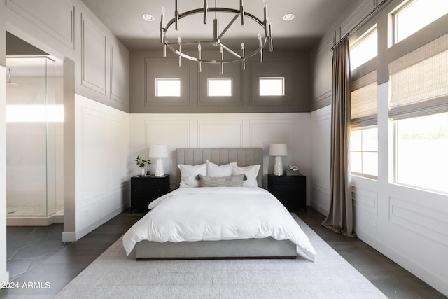 bedroom featuring a chandelier, dark hardwood / wood-style flooring, and multiple windows