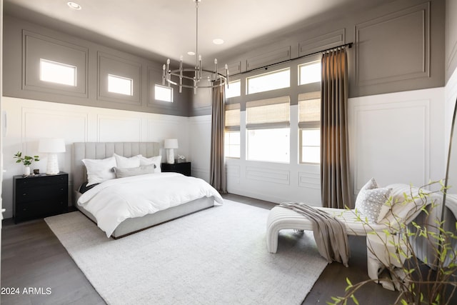 bedroom with dark hardwood / wood-style floors and an inviting chandelier