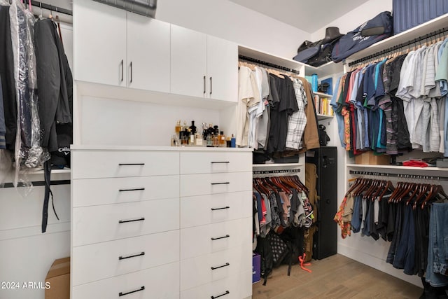 walk in closet with light hardwood / wood-style floors