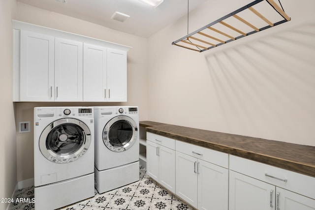 clothes washing area featuring cabinets and washing machine and dryer