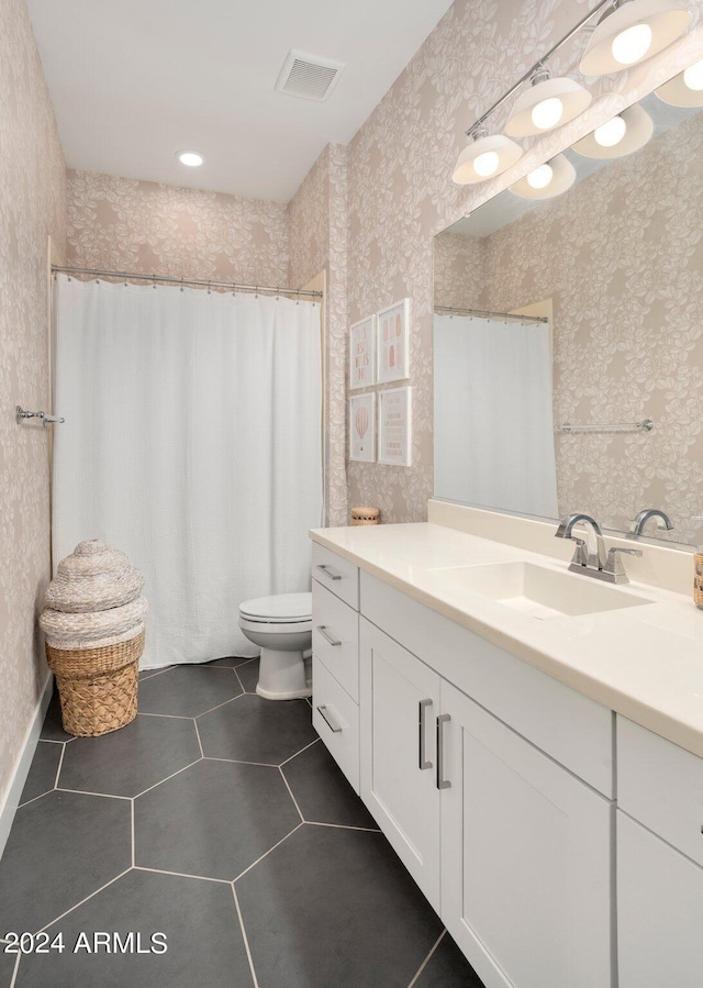 bathroom featuring tile patterned flooring, vanity, and toilet