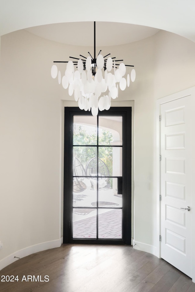 unfurnished dining area with a chandelier and hardwood / wood-style flooring