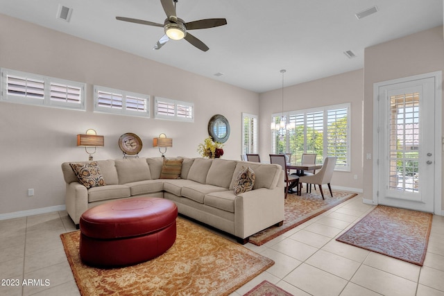 living room featuring light tile patterned flooring and ceiling fan with notable chandelier