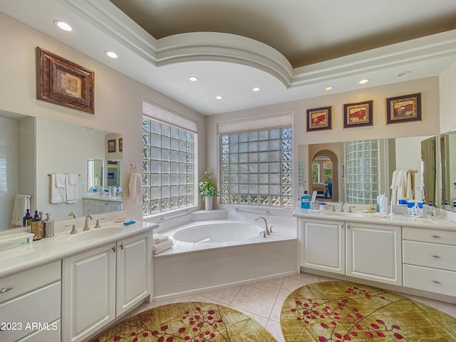 full bath featuring a garden tub, tile patterned flooring, two vanities, and a sink