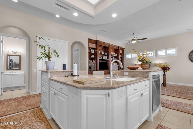 kitchen with white cabinetry, light tile patterned floors, an island with sink, and ceiling fan