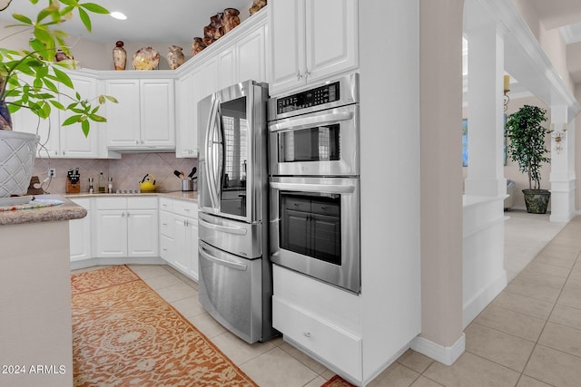 kitchen with light tile patterned floors, appliances with stainless steel finishes, and white cabinets