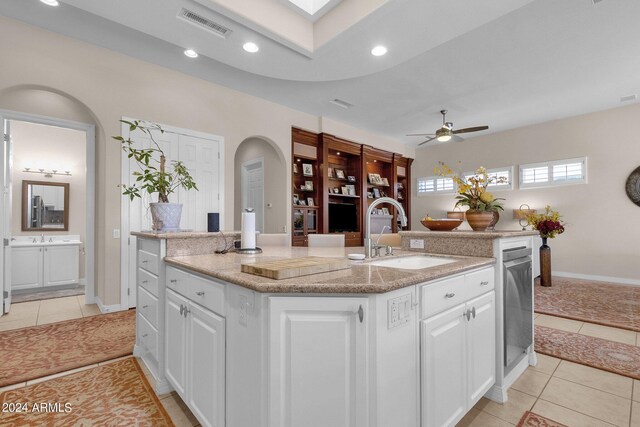 living room featuring ceiling fan with notable chandelier, a healthy amount of sunlight, and light tile patterned floors